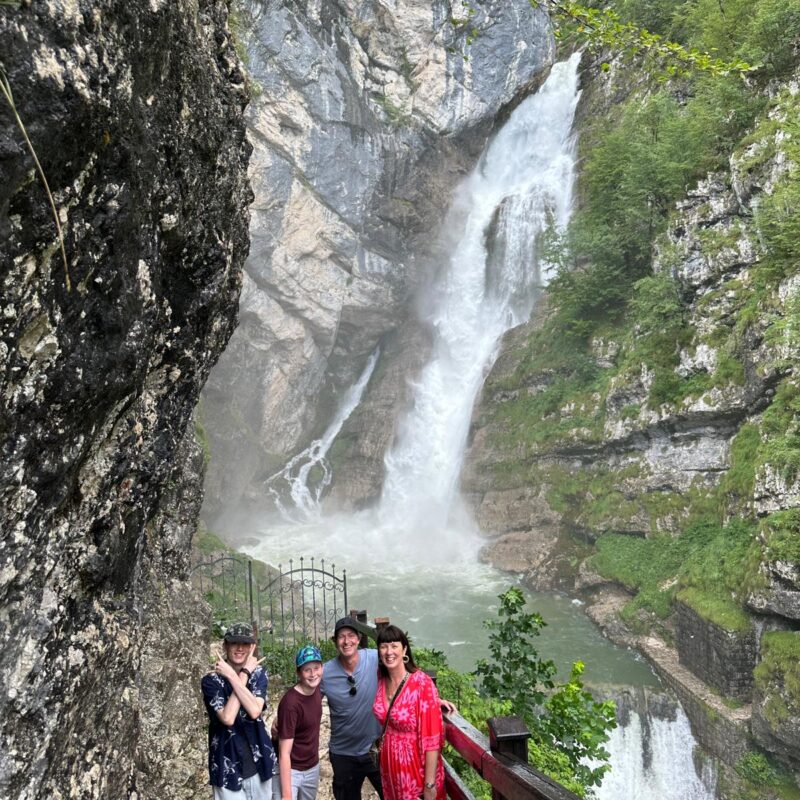 Family enjoying a scenic waterfall in Slovenia