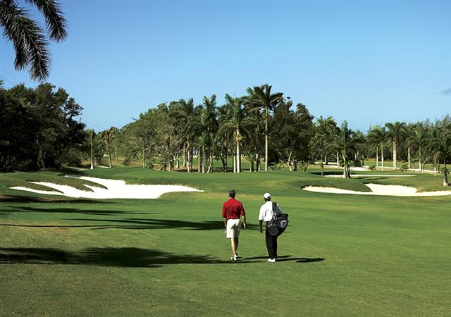 men walk on a golf course in jamaica