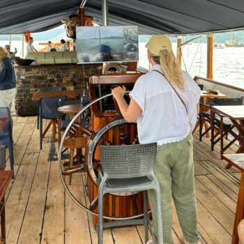 Val at the helm of a schooner in Paraty